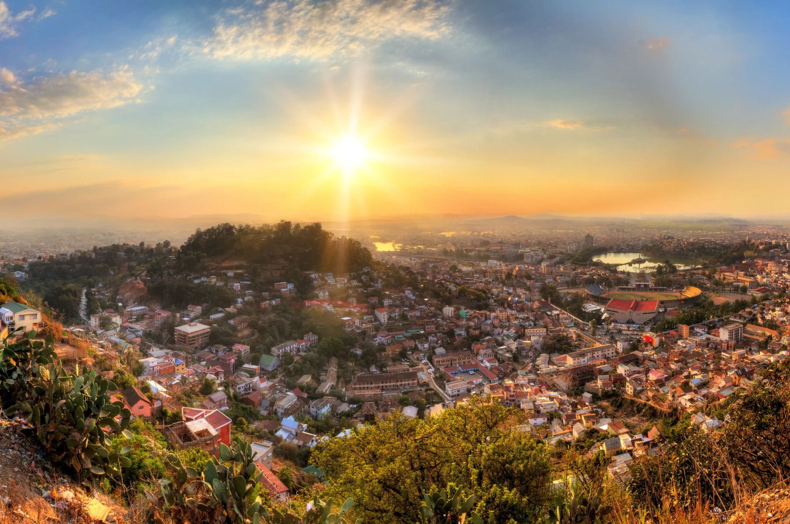 A golden Buddhist monastery roof with ornate finials overlooking misty mountain ridges at dawn